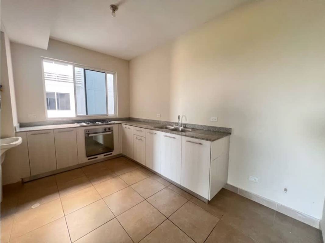 Minimalist apartment kitchen light cabinetry granite countertop gas stove