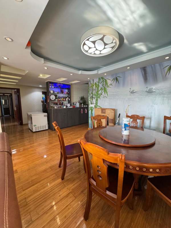 Dining area with round wooden table, wall mural, minibar lighting in PH Lexington Tower Panama City