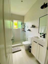 Open living room with large windows and porcelain tile floor in Bijao Panama