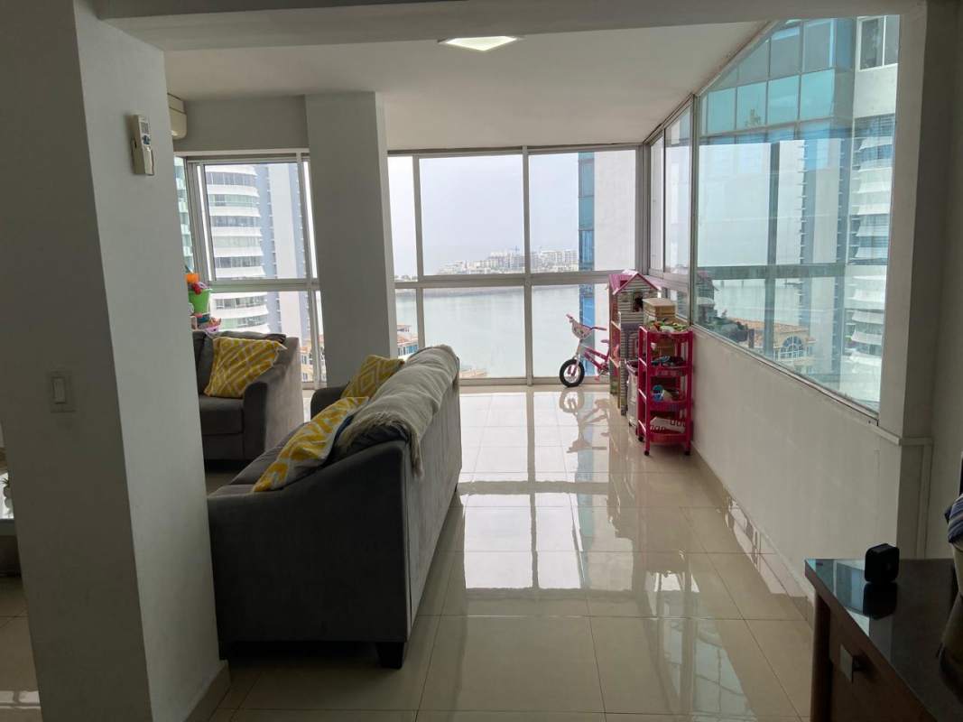 Living room with grey sofas, kids play space and sea view windows in PH Las Perlas Paitilla