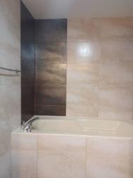 Modern bathroom with bathtub and accent wall PH Playa Blanca beachfront apartment Panama