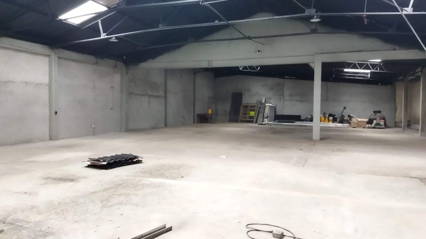 Large empty warehouse interior with skylights and steel beams La Loceria Panama