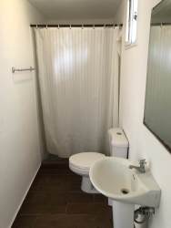 Minimalist bathroom with pedestal sink and shower curtain at Las Villas de Occidente Panama