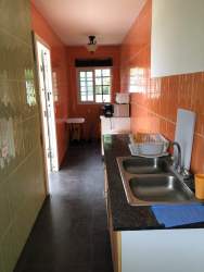 Living room with orange accent wall built-in shelving and mounted TV in Las Villas de Occidente Panama