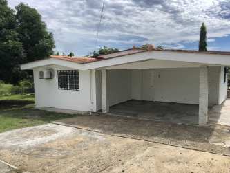 Modern hallway with tiled floors and wood pattern door at Las Villas El Chirú Panama