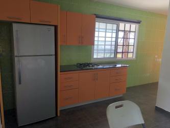 Compact galley kitchen with granite counters and tile walls in Las Villas de Occidente Panama