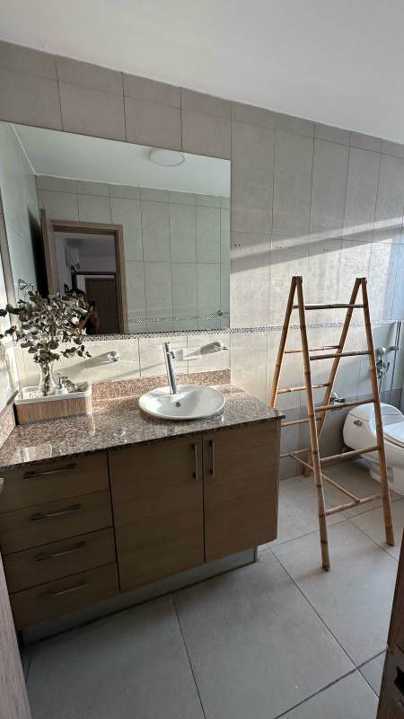 Modern bathroom with granite countertop, vessel sink, large mirror and glass-enclosed shower in PH Moon Tower