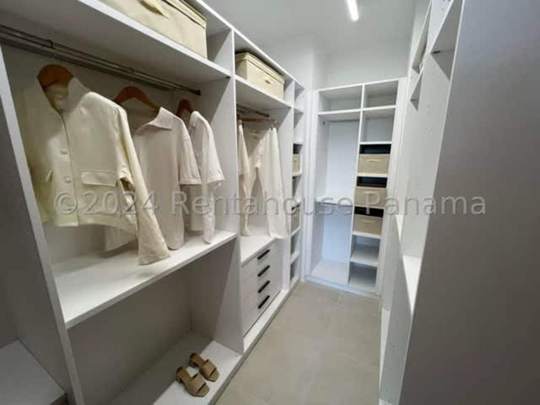 Spacious modern walk-in closet in duplex apartment with organized storage at PH Ocean House Santa Maria Panama
