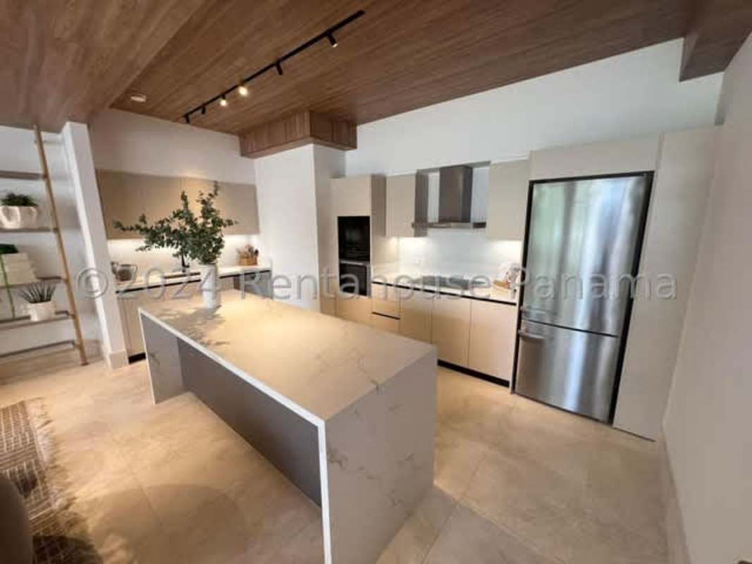 Beige luxury kitchen with island and stainless appliances in duplex Santa Maria Panama
