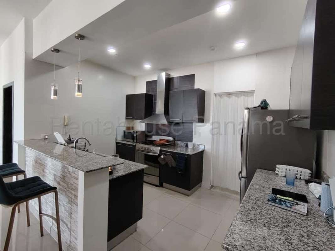 Spacious living room with red sofas, TV, foosball table in furnished PH Quadrat apartment Panama City