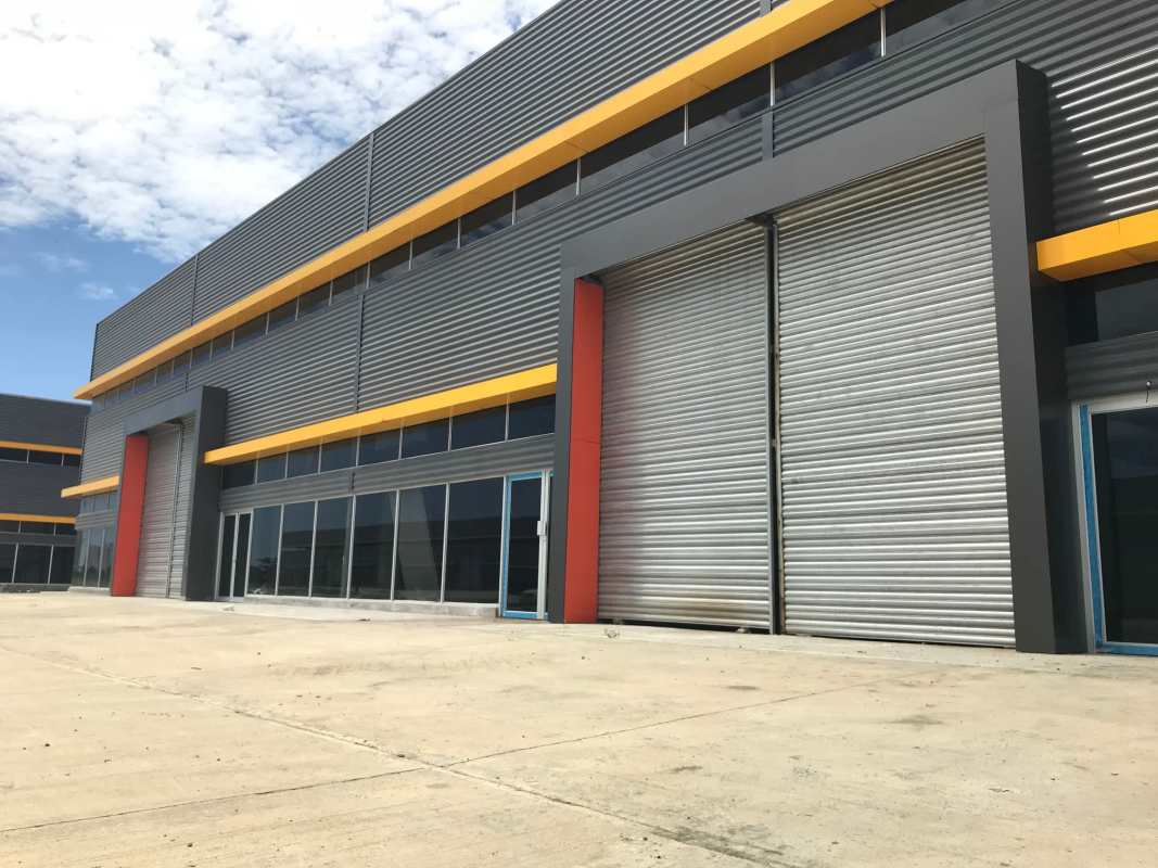 Modern industrial warehouses with large roller doors and container truck access near Tocumen Panama