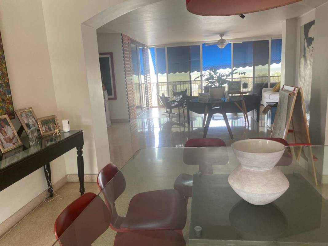 Modern dining area with glass table and tall windows in PH Las Llamas Coco del Mar