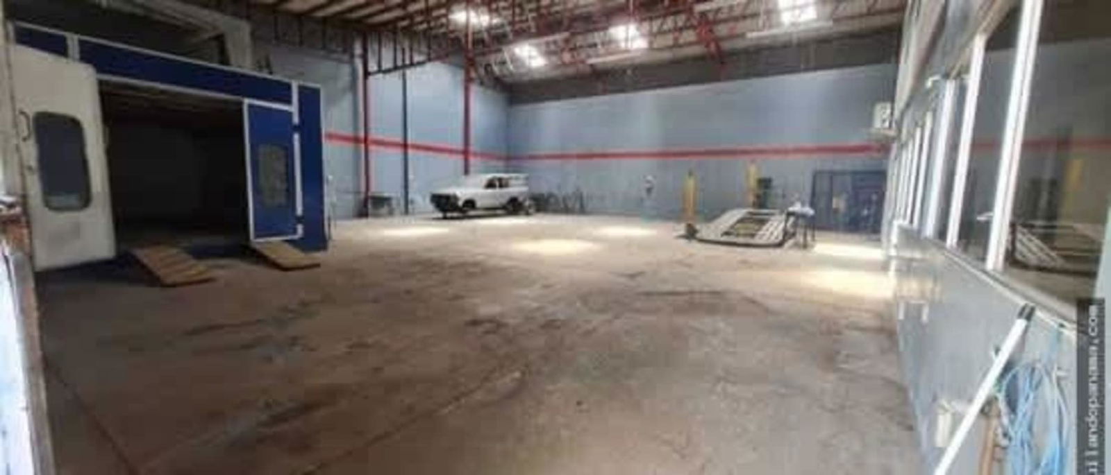 Warehouse interior with spray paint booth, vehicle area, high ceilings located in Panama City