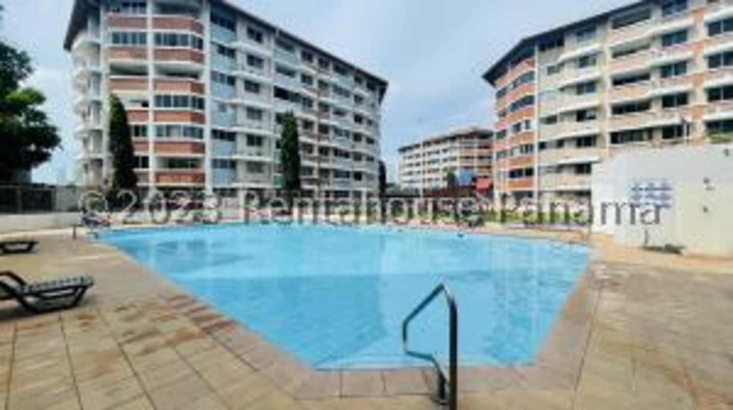 Outdoor pool with poolside seating surrounded by apartments Don Bosco Panama City