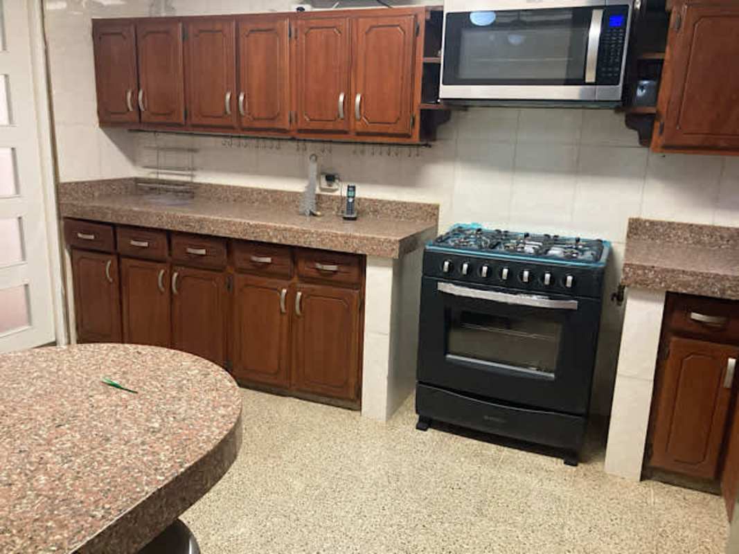 Traditional kitchen granite countertop round breakfast island gas stove microwave fridge rental in La Loma