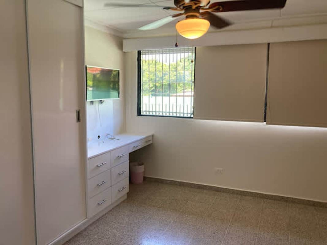 Bright empty bedroom with tile floor split AC ceiling fan and wardrobe La Loma rental house Panama City