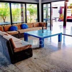 Bright living room with sectional sofa, sliding doors opening to terrace Costa Esmeralda Panama