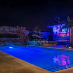 Swimming pool illuminated at night with tropical mural Costa Esmeralda Panama