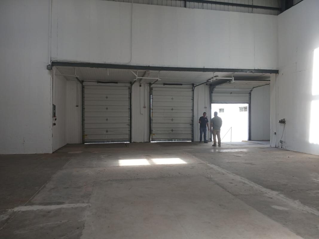 Warehouse space with exposed beams, concrete floor and natural lighting in Pedregal