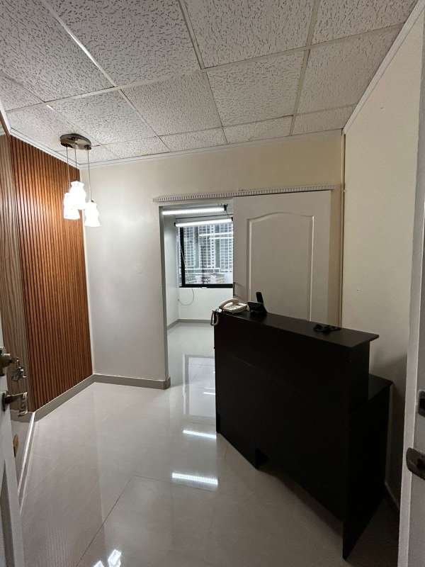 Reception desk with wood panel wall and pendant lights in medical office on Vía España Panama