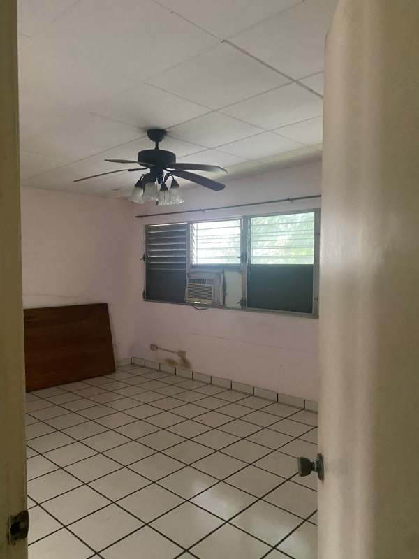 Bedroom with ceiling fan, closet, window AC in luxury house for sale San Francisco Panama City