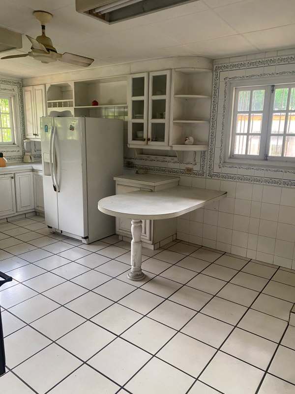 Interior staircase with wrought iron railings, chandelier, natural lighting luxury house Panama