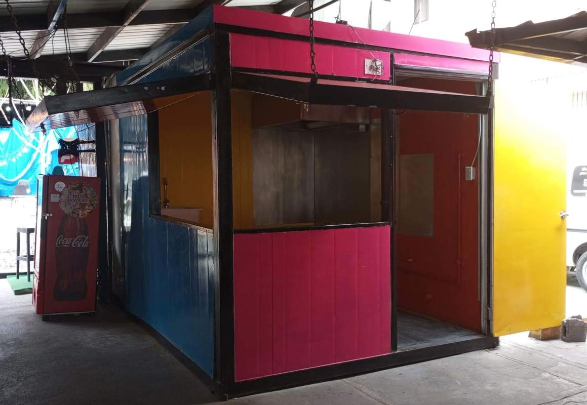 Vibrant small kiosk exterior with service window in Food Bazaar El Cangrejo Panama City