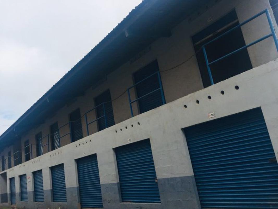 Exterior of two-story warehouse with multiple blue shutter doors, balconies, at ServiGaleras Chanis Panama City