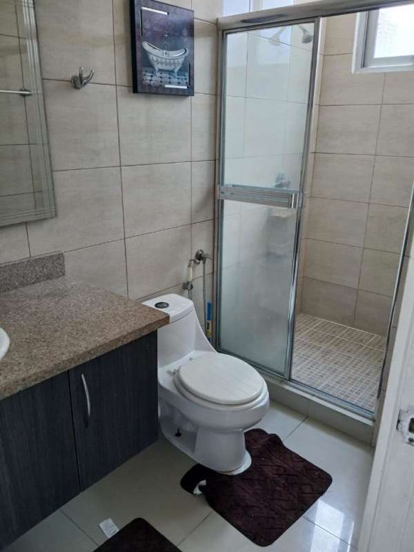 Modern bathroom with glass enclosure, granite vanity and beige tiles in PH El Cangrejo Plaza Panama
