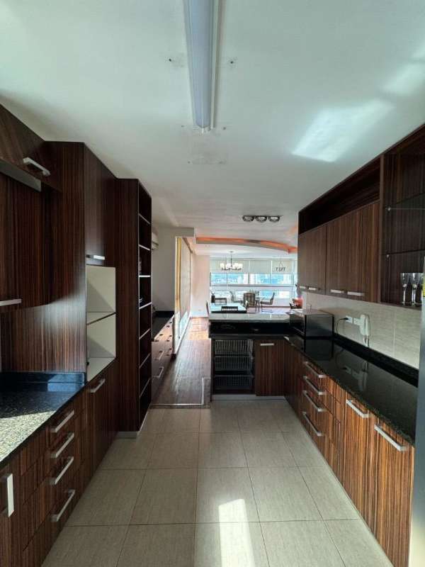 Kitchen with wood grain cabinets, granite countertops, open plan in PH San Francisco Bay Panama City