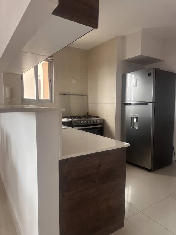 Bright kitchen with breakfast bar, fridge, stove, tile backsplash in PH Vista Hermosa Panama