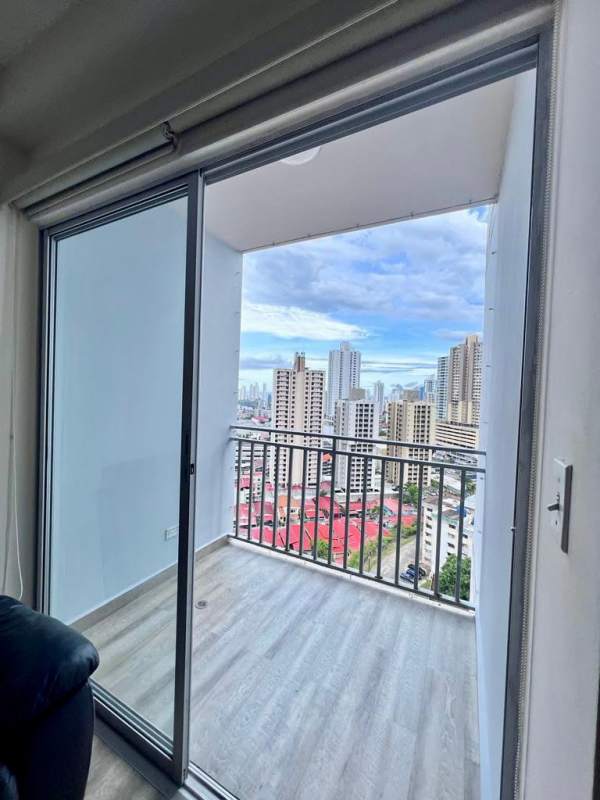 Apartment living room with sliding doors to balcony overlooking Panama City skyline at PH El Doral