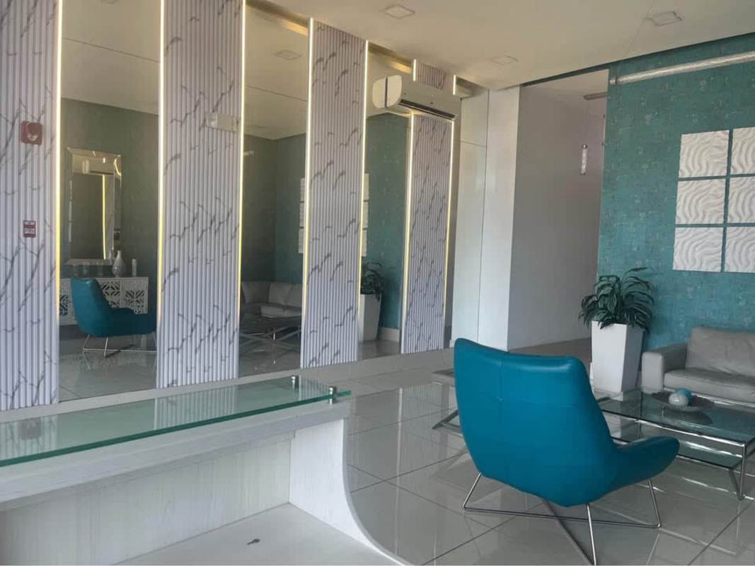 Contemporary building lobby with teal chairs and art decor PH Torres de Castilla Panama