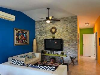 Colorful living room with accent stone wall and mounted TV Las Lajas Panama