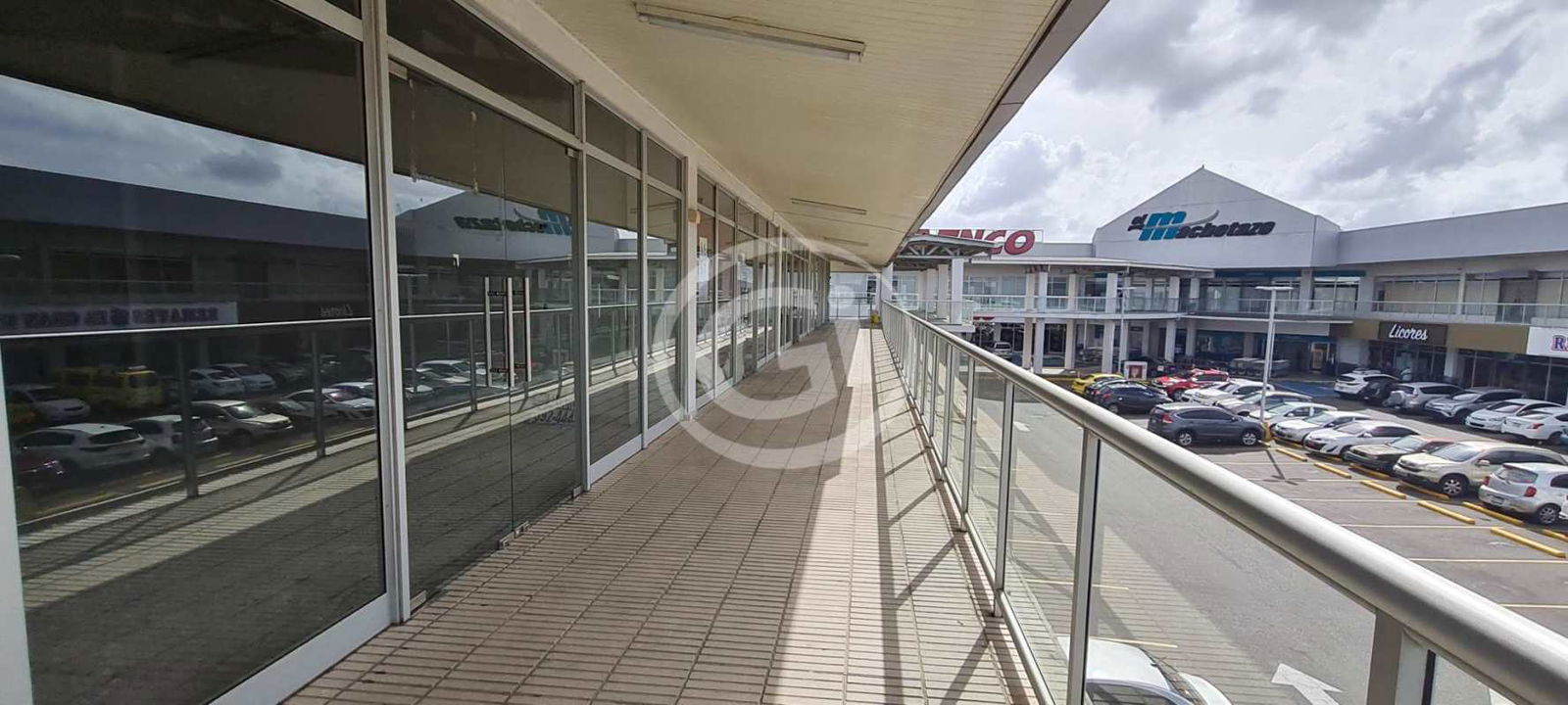 Blank retail unit interior with concrete floors and double height ceiling in Panama mall