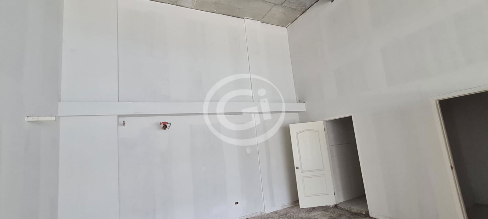 Open spacious raw retail space with exposed ceiling and concrete floor in Costa Sur Mall