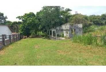 Vacant lot with unfinished concrete structure and natural landscape inside Coronado beach community Panama