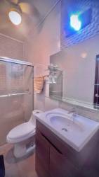 Modern bathroom with tiled walls, vanity mirror and shower in Chitré Panama