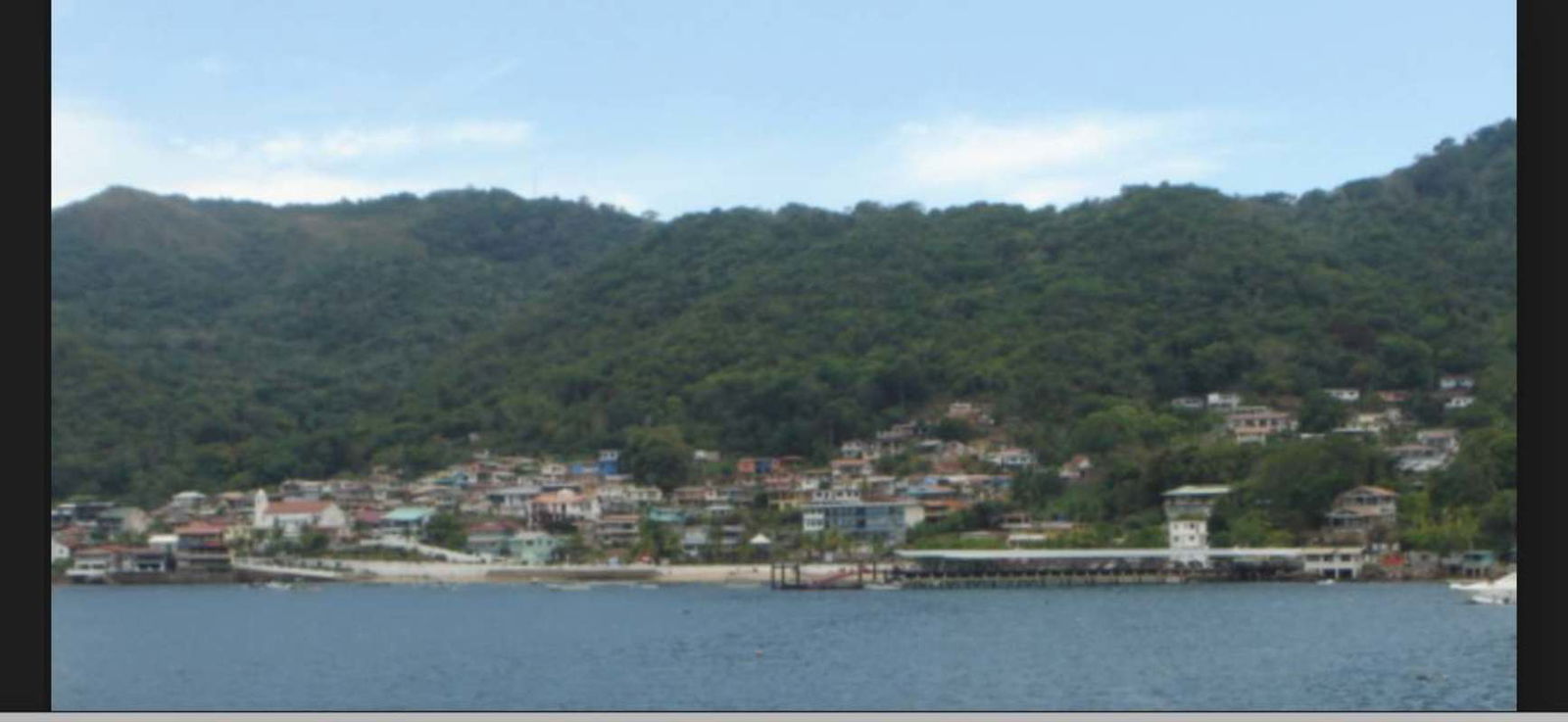 Hillside coastal village on Isla Taboga with ocean and mountain views ideal for development