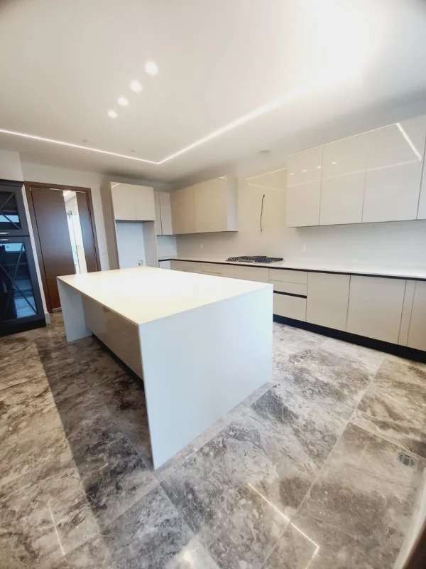 Contemporary kitchen with quartz island and marble floors in PH Empire Residences Santa María