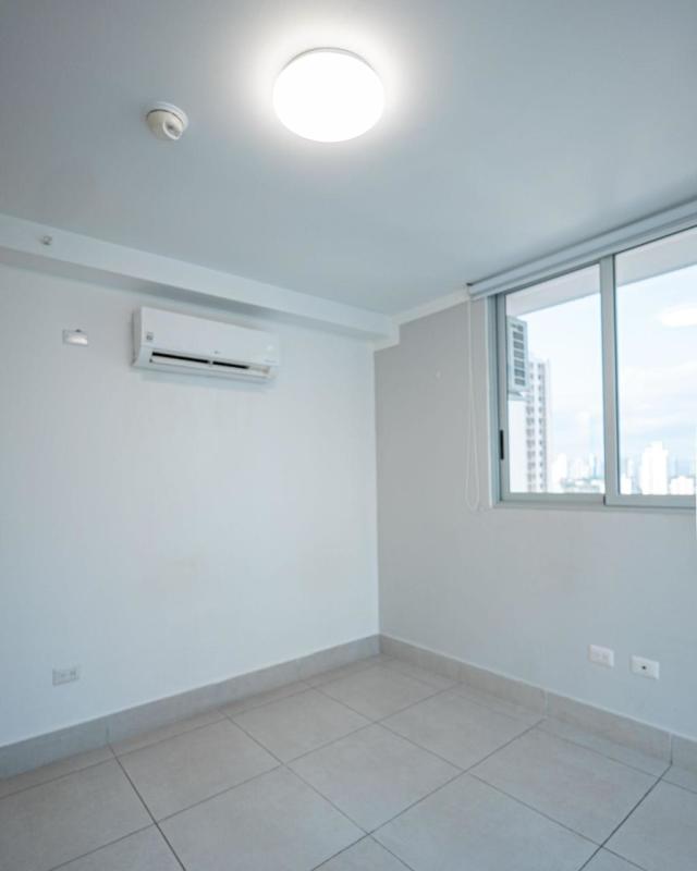 Bedroom with large windows offering city skyline views at PH Park City Obarrio Panama City