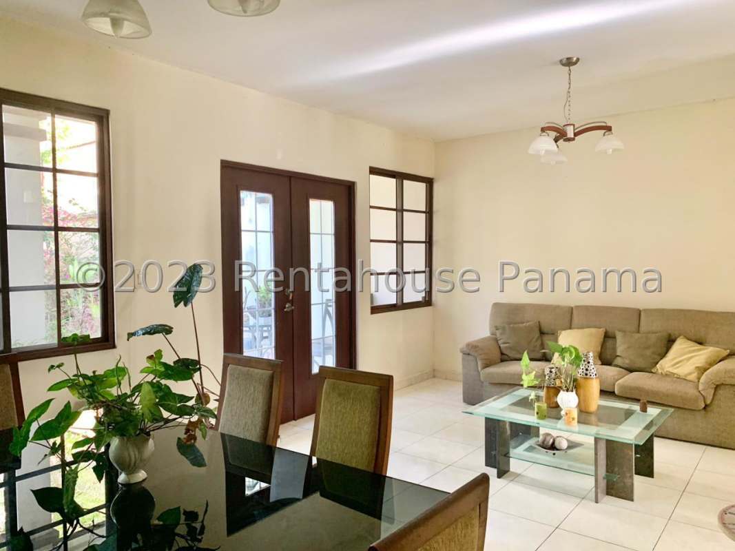 Spacious living and dining room with large windows, garden view, natural light in Mirador del Lago house Panama