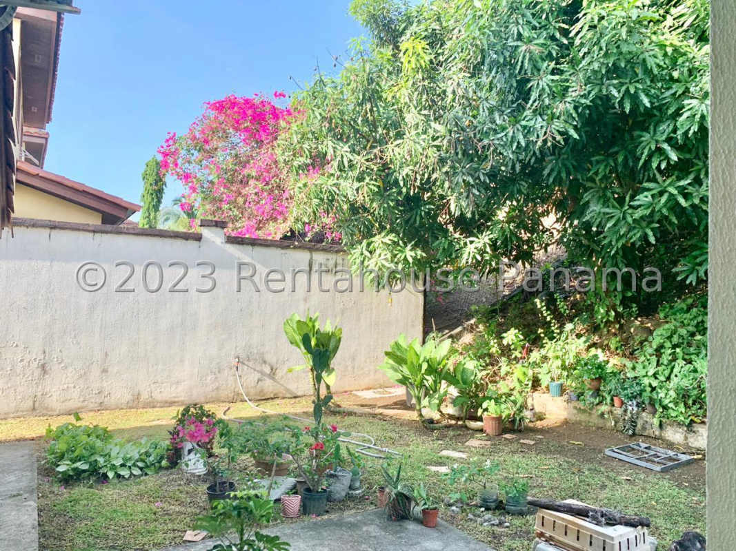 Covered patio with dining furniture, potted plants overlooking backyard Las Cumbres Panama