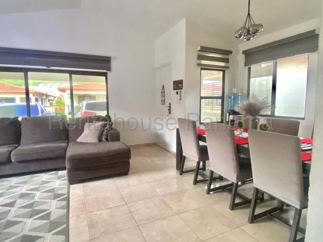 Spacious living room with patterned wall, TV, gray sofa, AC, PH Vistas del Lago Las Cumbres