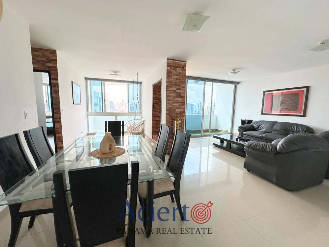 Living and dining space with large windows and hanging chair, city views at PH San Francisco Panama