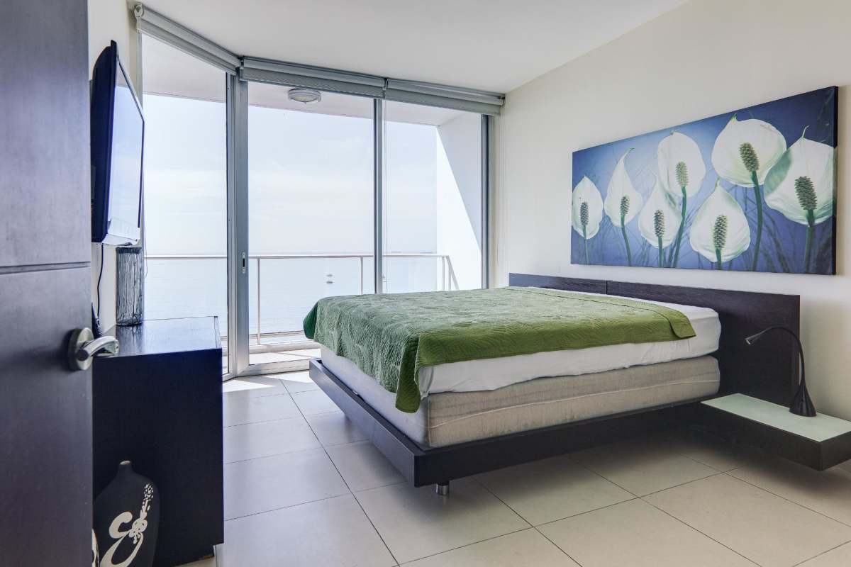 Elegant bathroom with double sinks, glass shower, mosaic tub in PH Destiny apartment Panama City