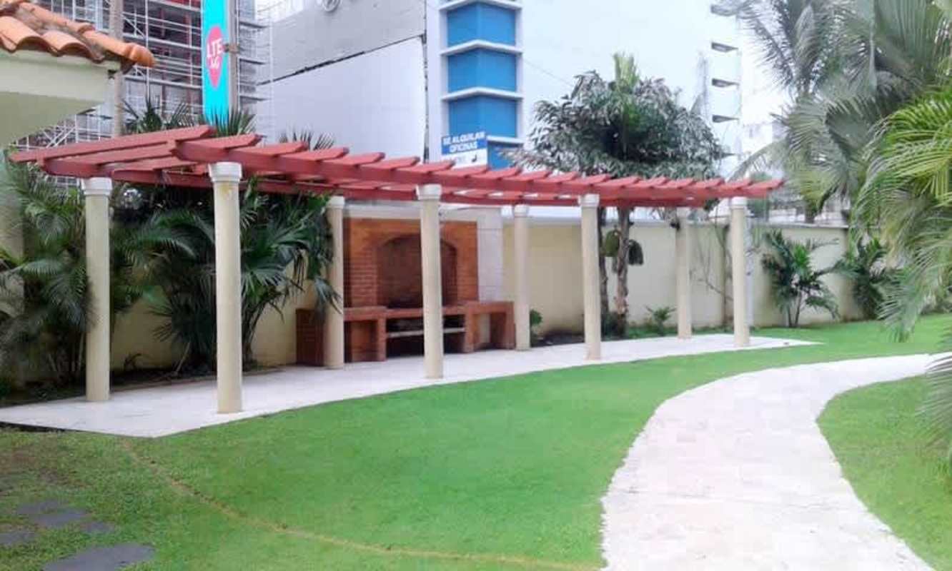Outdoor space with BBQ pergola, green lawn, walkway and tropical plants at PH Costa Pacifica Punta Pacifica Panama City
