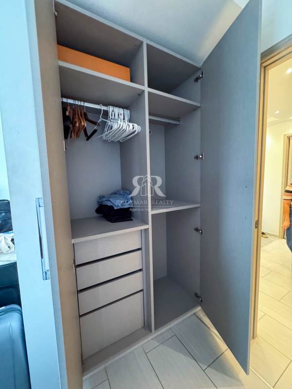 Open wardrobe with shelves and hangers inside bedroom at PH The Towers Panama