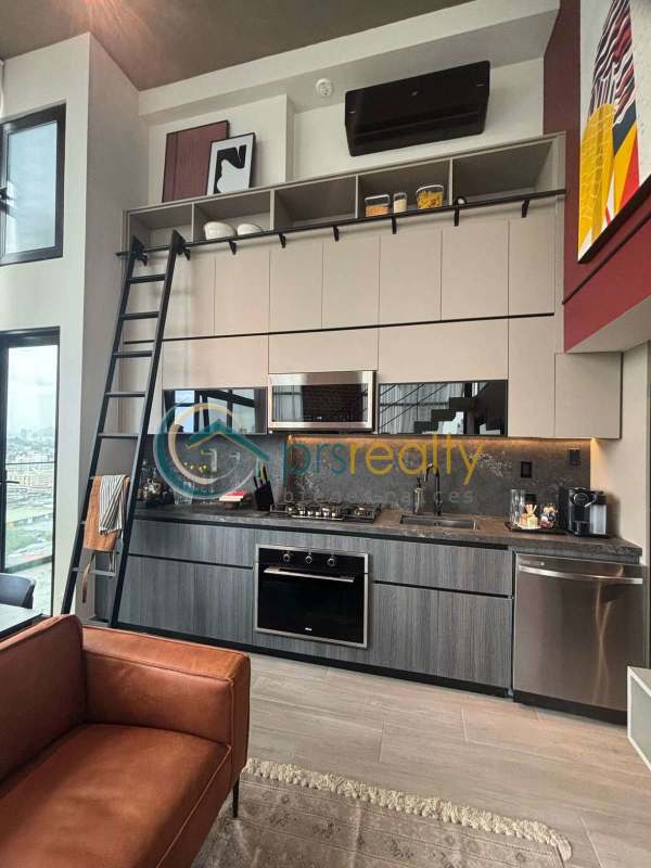 High-ceiling apartment kitchen with open shelves, ladder and modern finishes in PH Dovle Panama