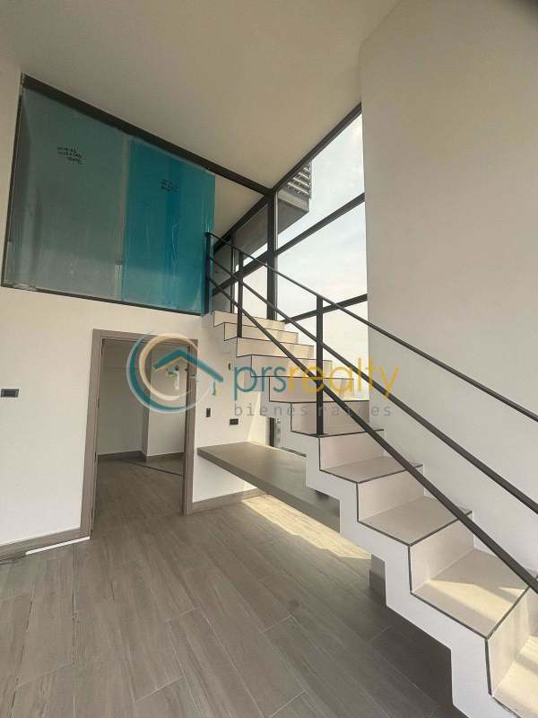 Spacious duplex apartment interior with floating stairs and double-height windows PH Dovle Panama